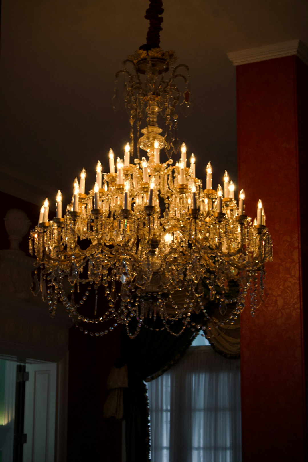 An ornate crystal chandelier illuminated with many bulbs